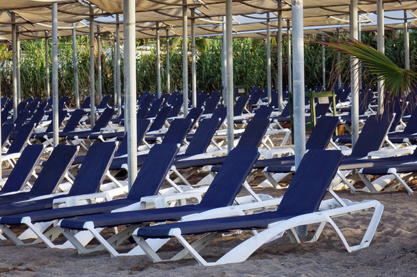Сонячні шезлонги з парасолькою на пляжі. Туристична індустрія
. - Фото, зображення