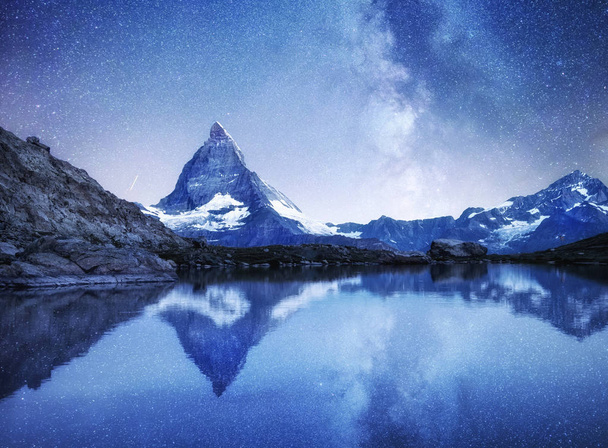 Matterhorn és a mérlegelés a víz felszínén, az éjszaka. Tejút felett Matterhorn, Svájc. Gyönyörű természeti táj a Svájcban - Fotó, kép