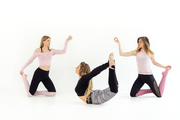 group of three girls young beautiful are dancing. yoga and pilates are practiced. white background   - 写真・画像