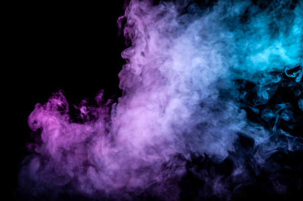 Clouds of isolated colored smoke: blue, red, green, pink; scrolling on a black background in the dark close up. - Photo, Image