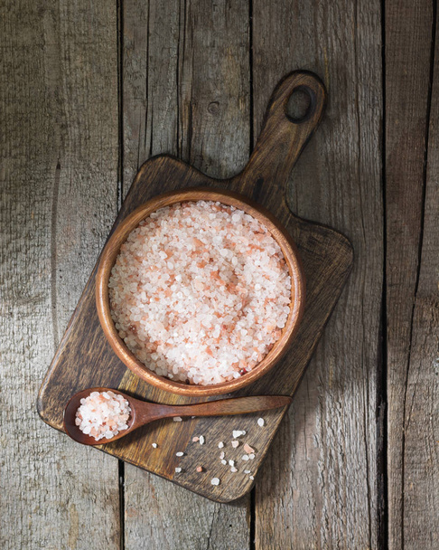 Sea pink salt in a wooden bowl on a wooden table. Rustic style - Foto, Imagen