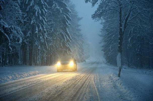 Χειμώνα χιονισμένο δρόμο με το αυτοκίνητο. Επικίνδυνη αυτοκίνητο οδήγηση στα βουνά το χειμώνα. Ιδέα για τη μεταφορά, τα αυτοκίνητα και ταξίδια. - Φωτογραφία, εικόνα
