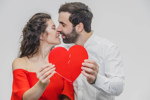 Portrait of an Excessive Couple. Hold two pieces of carded paper and kiss. Women dressed in red mens dresses in a white shirt. - Fotoğraf, Görsel