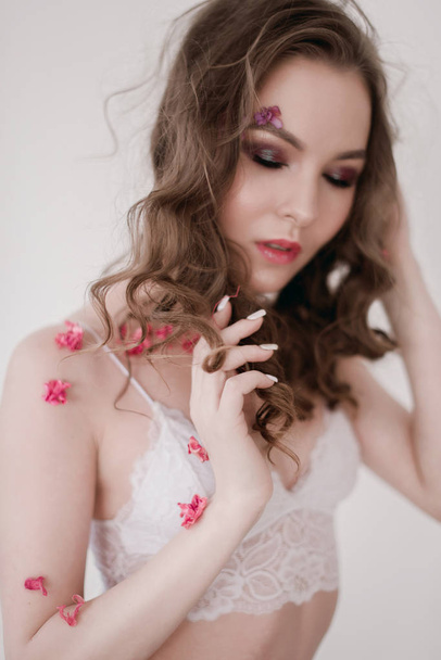 Cosméticos e manicure. Retrato de close-up de mulher atraente com flores secas no rosto, cor pastel, maquiagem perfeita e pele. Retrato retocado de primavera fresco, na moda
 - Foto, Imagem