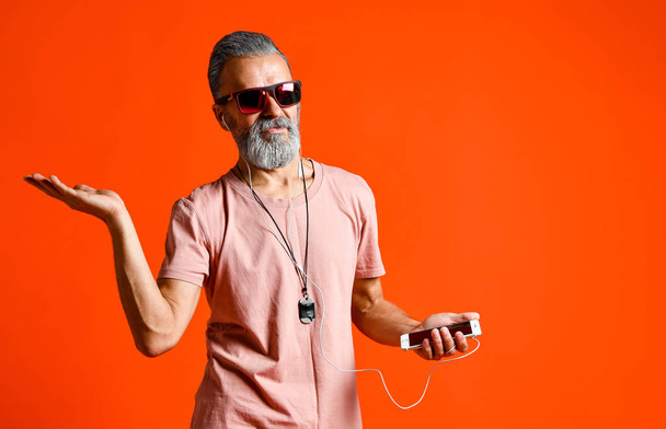 An image of an elderly bald head man listening to music with headphones - 写真・画像