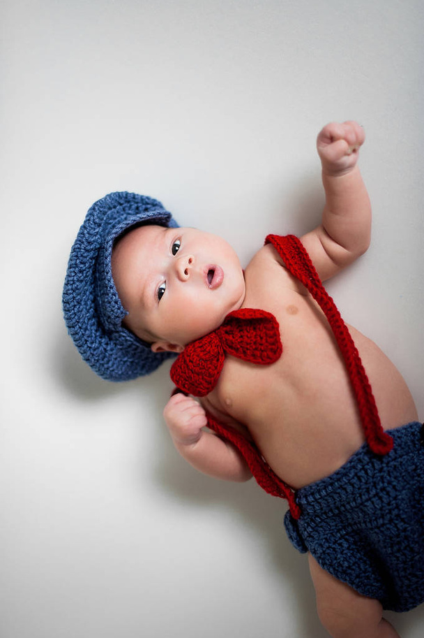 ニットの帽子と赤い蝶ネクタイで男の子の赤ちゃん - 写真・画像