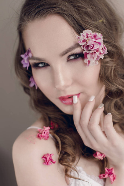 Cosmetici e manicure. Ritratto ravvicinato di donna attraente con fiori secchi sul viso, colore pastello, trucco perfetto e pelle. Ritocco fresco, alla moda, ritocco primaverile
 - Foto, immagini