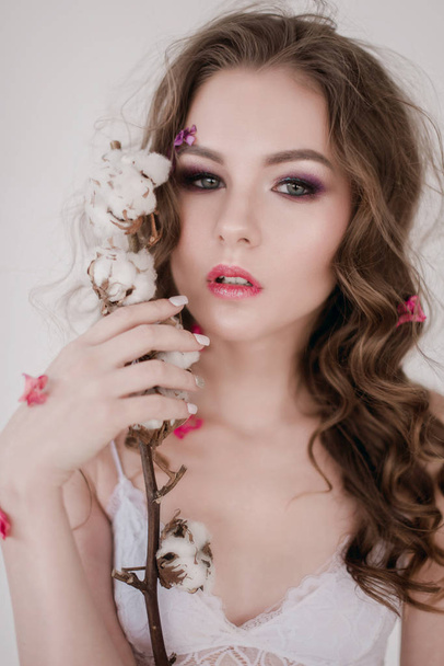 Cosmetics and manicure. Close-up portrait of attractive woman with dry flowers on her face, pastel color, perfect make-up and skin. Fresh, trendy, spring retouched portrait - Fotoğraf, Görsel