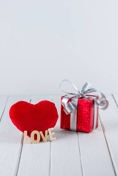 Valentines Day background with Red gift box, Heart shape and Wooden letters word "LOVE" on white wooden table and copy space for your graphic. - 写真・画像