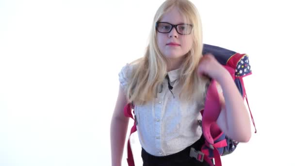 hermosa colegiala con una mochila escolar y con gafas posando en el estudio sobre un fondo blanco
 - Metraje, vídeo