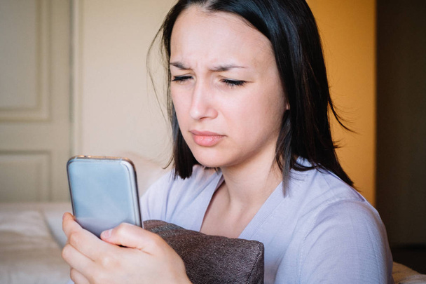 Celosa mujer enojada leyendo el mensaje en el teléfono móvil
 - Foto, Imagen
