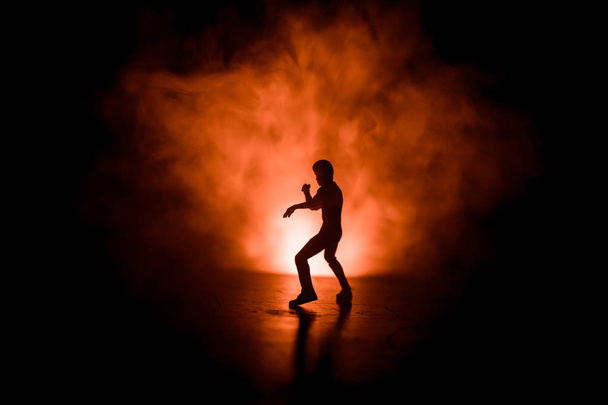 Karate-Athleten kämpfen scene.character Karate. Posing-Figur Kunstwerk Dekoration. Sport Gerangel oder Mann praktiziert Karate auf dekorierten nebligen Hintergrund mit Licht. - Foto, Bild