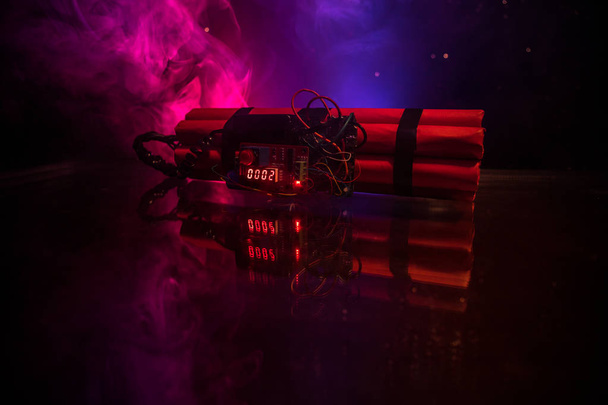 Image of a time bomb against dark background. Timer counting down to detonation illuminated in a shaft light shining through the darkness, conceptual image - Photo, Image