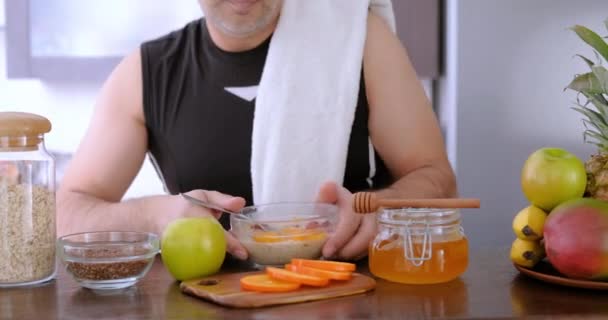 Adult man eating a healthy oatmeal after a workout. - Metraje, vídeo