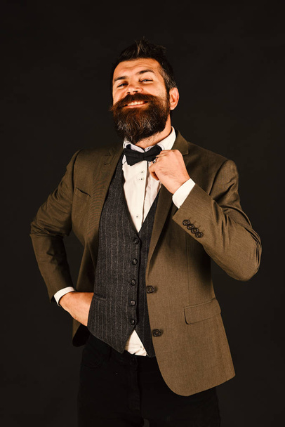 Businessman with beard adjusting his bow tie - Fotó, kép