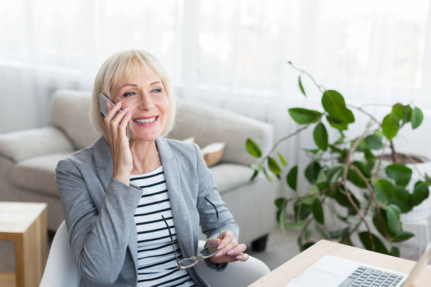 Femme d'affaires âgée faisant un appel téléphonique à un client potentiel
 - Photo, image