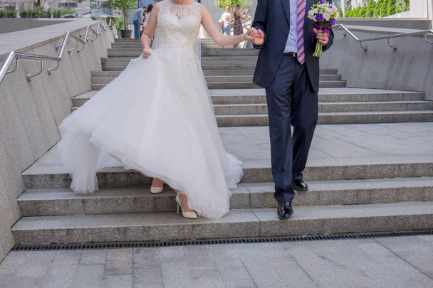 bride and groom walk down the stairs - Фото, зображення