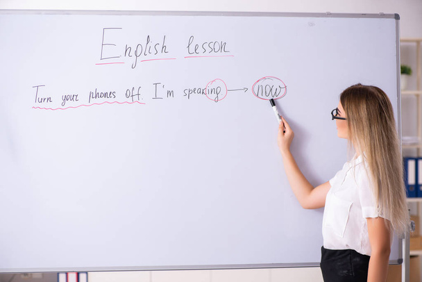 Νεαρή γυναίκα αγγλικής γλώσσας δάσκαλος στέκεται μπροστά από το β - Φωτογραφία, εικόνα