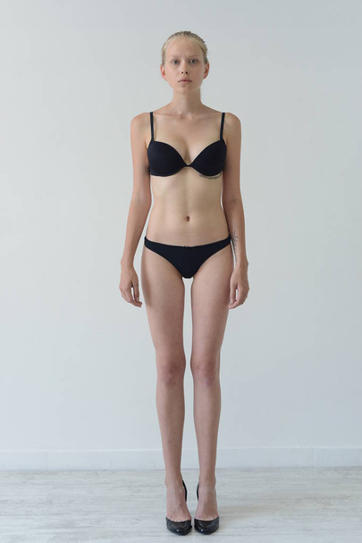 model tests girl in black lingerie with tattoo posing in Studio on grey background - Foto, Imagem