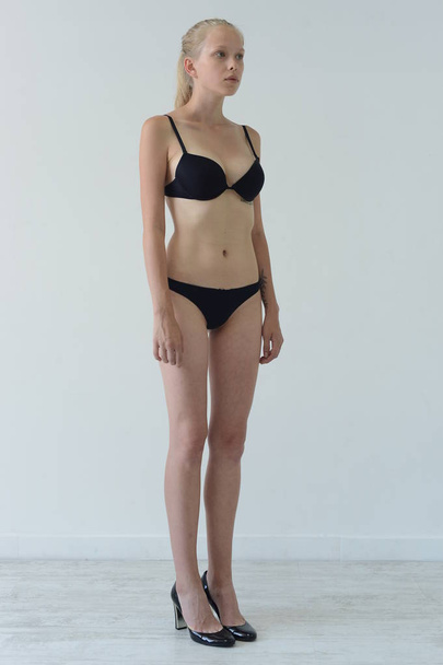 model tests girl in black lingerie with tattoo posing in Studio on grey background - Foto, Bild