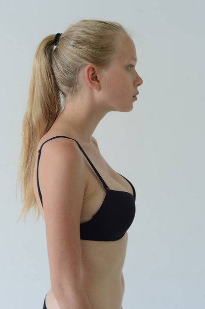 model tests girl in black lingerie with tattoo posing in Studio on grey background - Valokuva, kuva