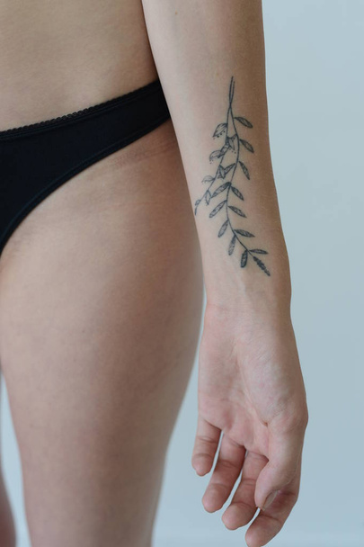 model tests girl in black lingerie with tattoo posing in Studio on grey background - Zdjęcie, obraz