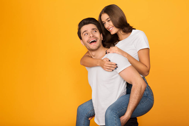 Щасливий чоловік носить свою дівчину на спині
 - Фото, зображення