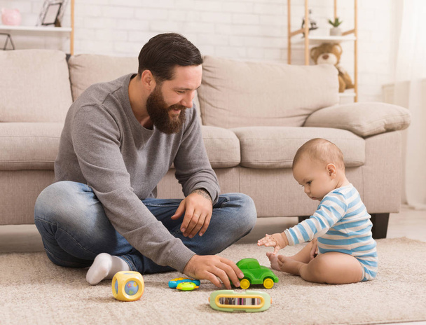 Giovane padre e il suo bambino ragazzo giocare con giocattolo auto
 - Foto, immagini