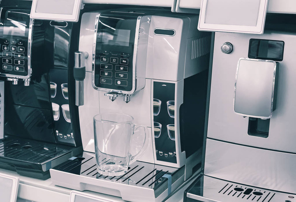 Στο παράθυρο του καταστήματος προς πώληση παρουσιάζει μια μοντέρνα καφέ μηχανές των διαφόρων μοντέλων. - Φωτογραφία, εικόνα