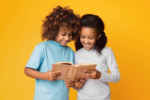 Roztomilé holčičky čtení knihy proti zdi - Fotografie, Obrázek