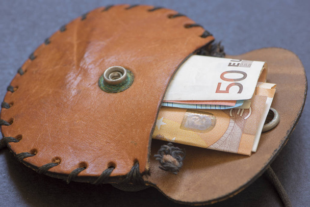 Une vieille bourse de couleur marron avec de l'argent à l'intérieur
 - Photo, image