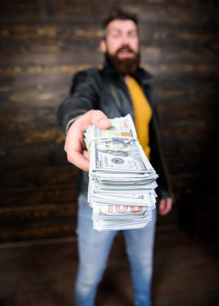 Man brutal bearded hipster wear leather jacket and hold cash money. Illegal profit and black cash. Guy mafia dealer with cash profit. Man give cash money bribe. Richness and wellbeing. Mafia business - Photo, image