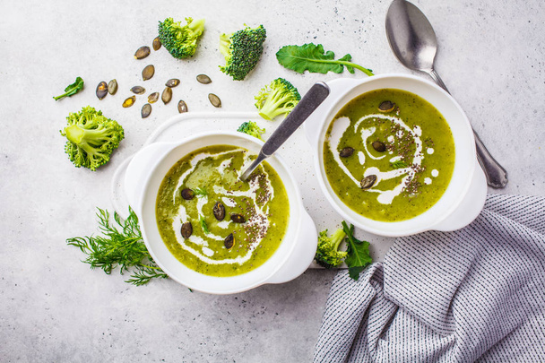 Vegan detox broccoli cream soup with coconut cream and pumpkin seeds in a white bowl. Plant based food concept. - Foto, Imagen