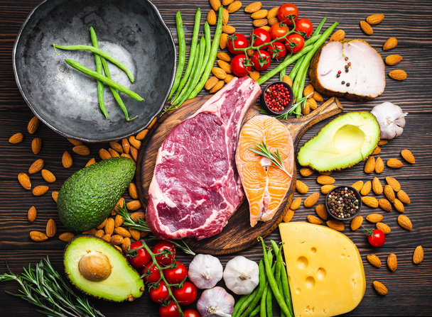 Making dinner with low carbs ingredients for healthy eating concept and weight loss, top view. Keto foods: meat, fish, avocado, cheese, vegetables, nuts. Ketogenic diet, organic clean eating  - Foto, immagini