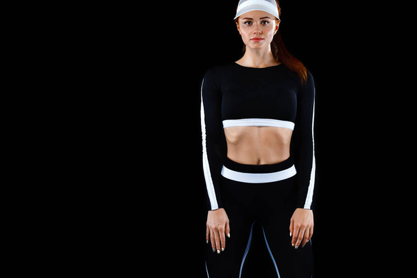 Strong athletic woman , posing on black background wearing in sportswear. Energy fitness and sport motivation. Copy space. - Фото, изображение