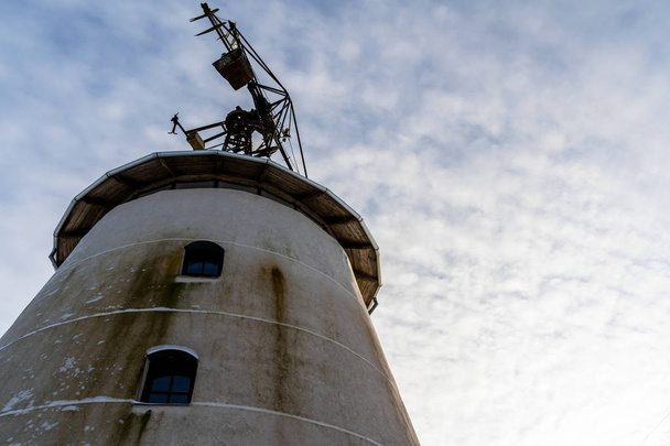 Closeup of Old Abandoned Windmill with Blue Skies in Background in Winter - Concept of Fun and Joy - Photo, Image