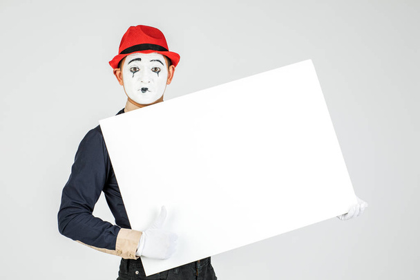happy MIME artist holding a blank white Board, on a white background - Zdjęcie, obraz