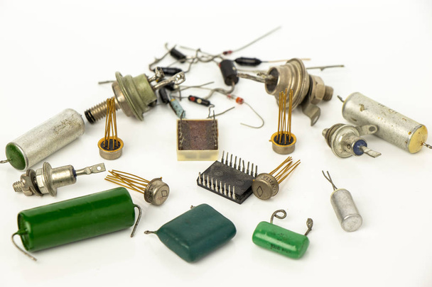 Bodegón de componentes electrónicos sobre fondo blanco. Dispersión de microcircuitos, diodos, tiristores y condensadores
. - Foto, Imagen