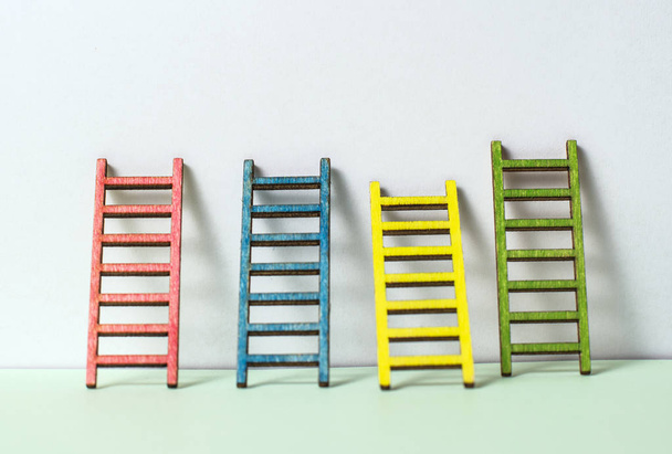 Multicoloured ladders on wall. Pastel tones. Concept for success and growth. Business metaphors. - Foto, imagen
