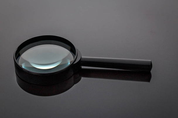 Old magnifying glass in black plastic frame - Fotoğraf, Görsel