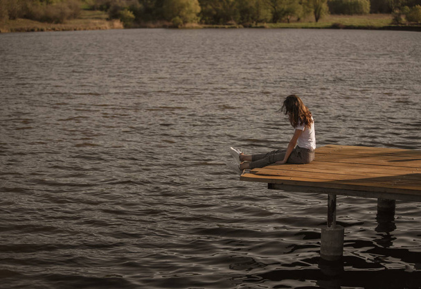 Casual woman on pier above lake water - Фото, зображення