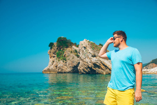 uomo in piedi con acqua di mare blu chiaro su sfondo. vacanze estive
 - Foto, immagini