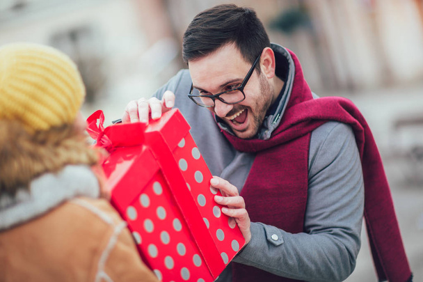 Woman giving man a surprise gift  - Foto, Imagen