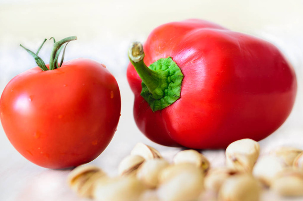 Rote Tomate und Paprika mit Pistazien auf weien Hintergrund - Φωτογραφία, εικόνα