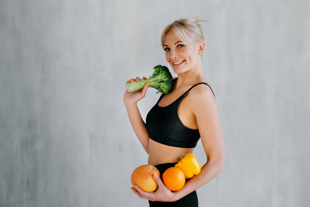 donna sportiva che tiene frutta e verdura fresca in mano, concetto di alimentazione sana
 - Foto, immagini