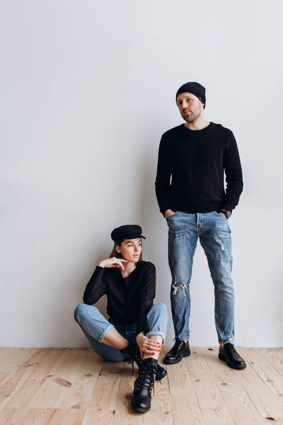 Two hipster models: a man and a woman in a blank black t-shirt, jeans and posing. in a black hat, cap, love, kisses - Valokuva, kuva