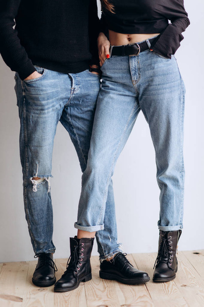 Two hipster models: a man and a woman in a blank black t-shirt, jeans and posing. in a black hat, cap, love, kisses - Fotó, kép