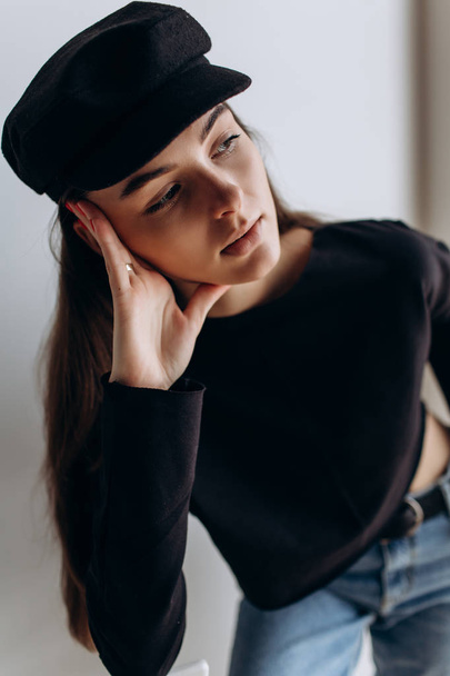 Beautiful girl in a black cap, black golf, blue jeans! Natural light, smart casua, street casual - Photo, Image