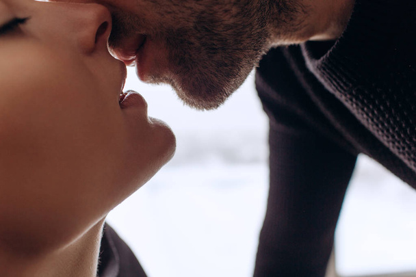 Крупним планом молода романтична пара цілується і насолоджується компанією один одного вдома
. - Фото, зображення