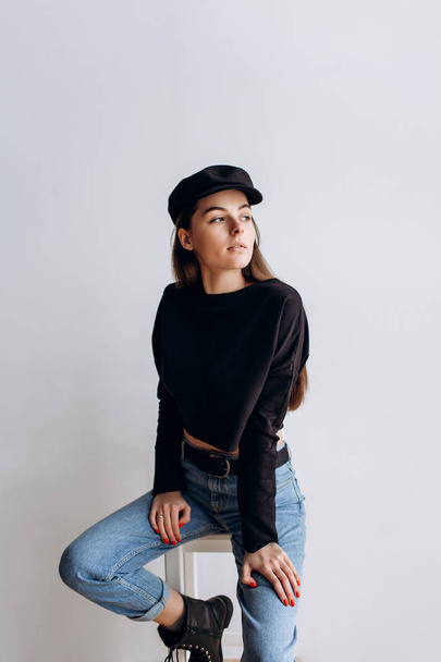 Beautiful girl in a black cap, black golf, blue jeans! Natural light, smart casua, street casual - Foto, afbeelding